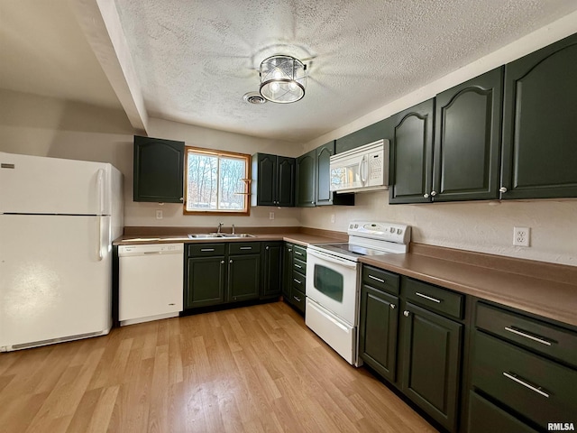 kitchen featuring a textured ceiling, sink, light hardwood / wood-style floors, and white appliances