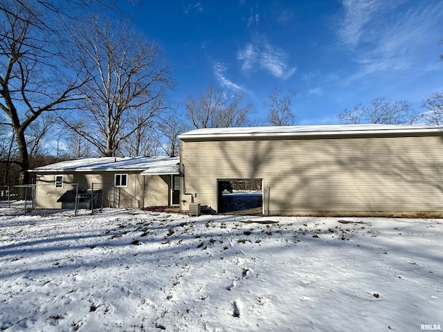 snow covered property with central air condition unit