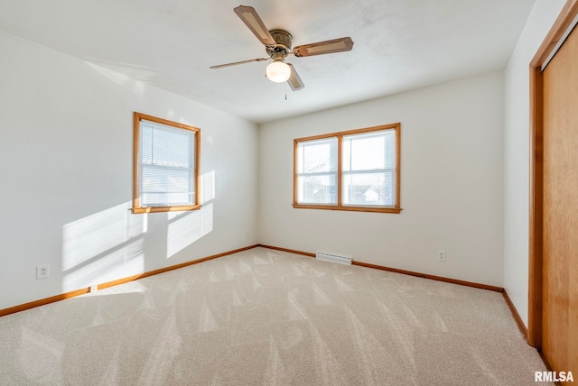 unfurnished bedroom with ceiling fan, a baseboard heating unit, a closet, and light carpet