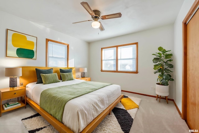 carpeted bedroom with ceiling fan and a closet