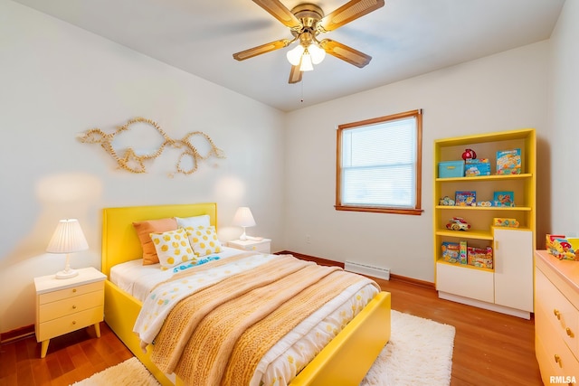 bedroom featuring ceiling fan, baseboard heating, and light hardwood / wood-style floors