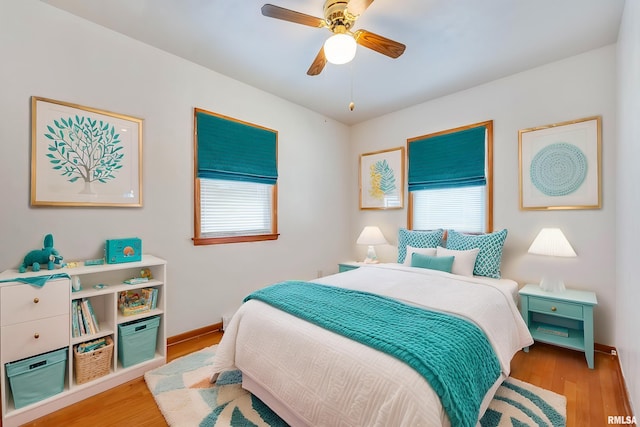 bedroom featuring ceiling fan, light wood-type flooring, and multiple windows