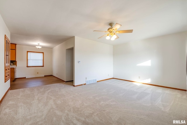 unfurnished room with light carpet, ceiling fan, and a baseboard radiator