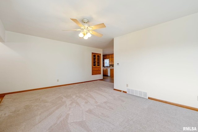 spare room featuring ceiling fan and carpet