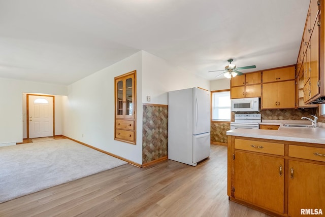 kitchen featuring ceiling fan, decorative backsplash, sink, white appliances, and light hardwood / wood-style flooring