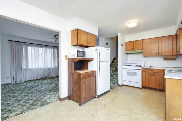 kitchen featuring ceiling fan, light colored carpet, white appliances, and sink