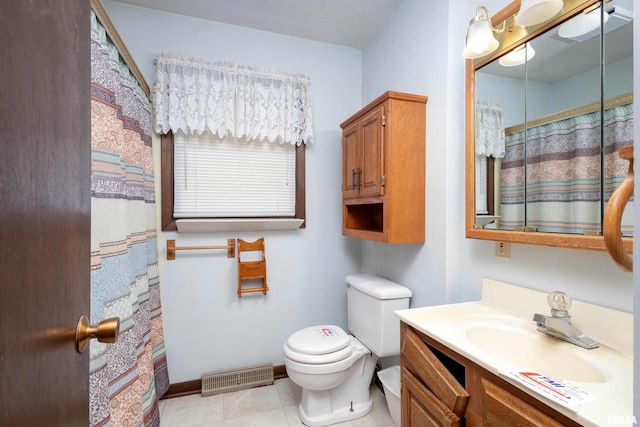 bathroom with toilet, vanity, and tile patterned floors