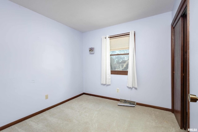 unfurnished room featuring light colored carpet