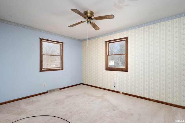 carpeted spare room featuring ceiling fan