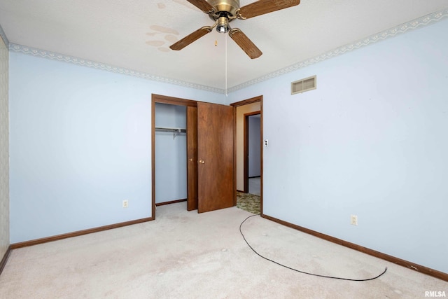 unfurnished bedroom with ceiling fan, light carpet, and a closet