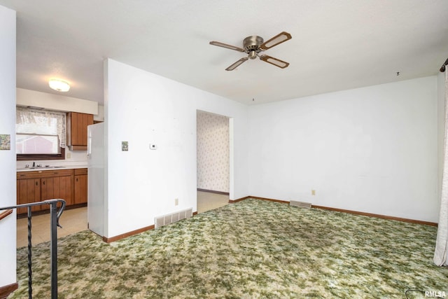 living room with light carpet, ceiling fan, and sink