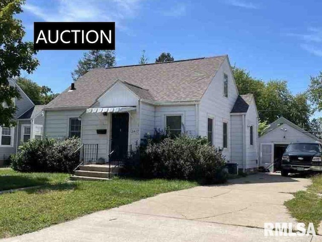 bungalow-style house featuring an outbuilding, a garage, and a front yard