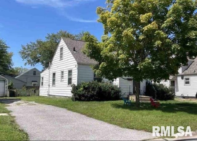 view of front of property featuring a garage and a front lawn