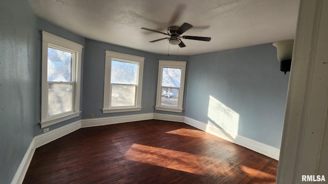 unfurnished room with ceiling fan, a textured ceiling, and dark hardwood / wood-style flooring