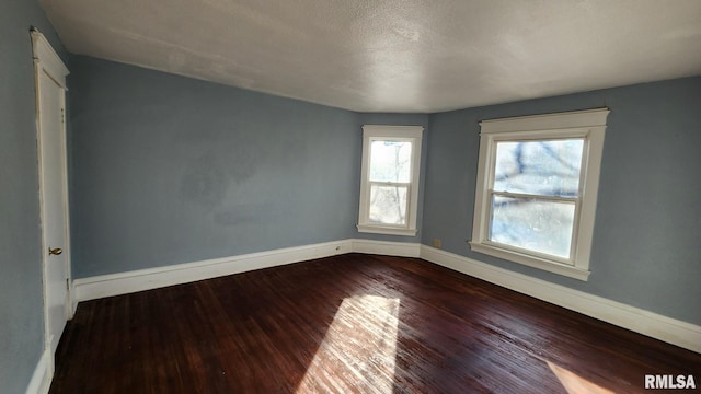 empty room featuring hardwood / wood-style flooring and a textured ceiling