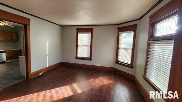 spare room featuring ceiling fan, dark hardwood / wood-style floors, a wealth of natural light, and ornamental molding