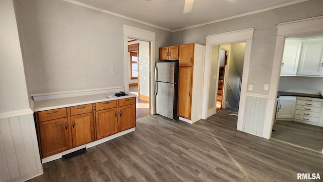 kitchen with dark hardwood / wood-style floors, ornamental molding, stainless steel fridge, and ceiling fan