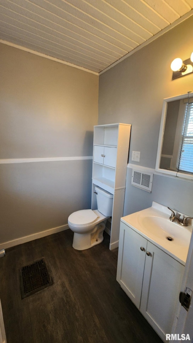 bathroom featuring wood-type flooring, toilet, vanity, and ornamental molding