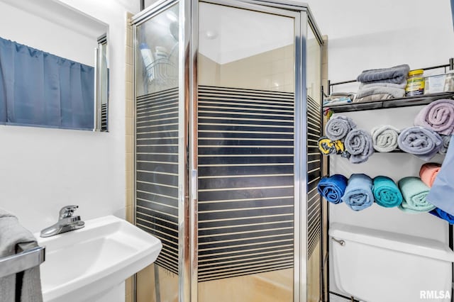 bathroom featuring sink, toilet, and walk in shower