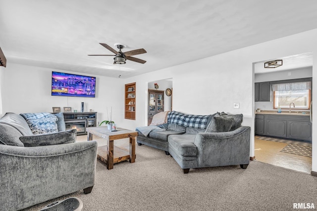 living room featuring ceiling fan, sink, and carpet