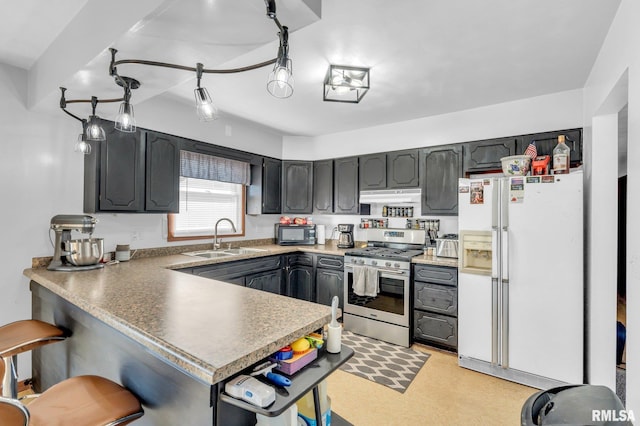 kitchen featuring white refrigerator with ice dispenser, kitchen peninsula, stainless steel range with gas cooktop, and sink