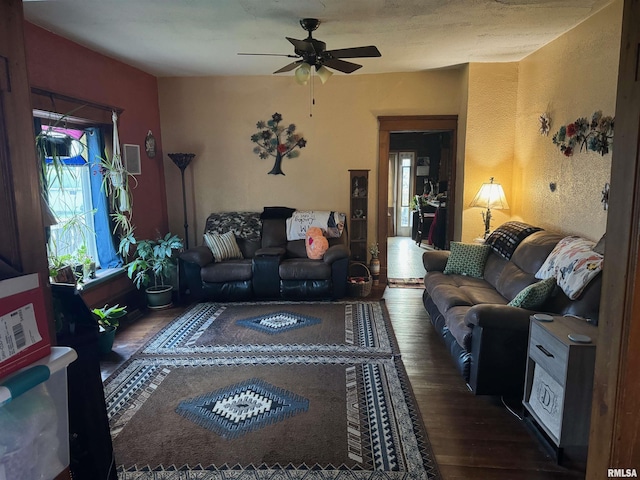 living room featuring ceiling fan and dark hardwood / wood-style flooring