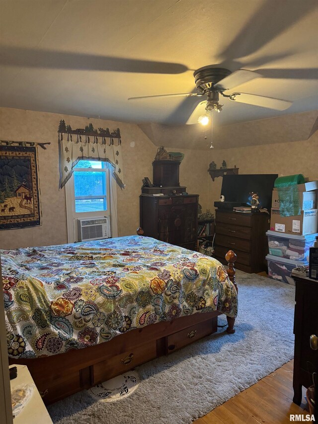 bedroom featuring ceiling fan, cooling unit, and hardwood / wood-style floors