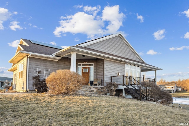 view of front of house with a front yard and solar panels