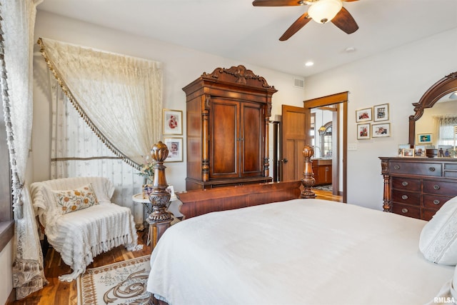 bedroom featuring ceiling fan, hardwood / wood-style floors, and multiple windows