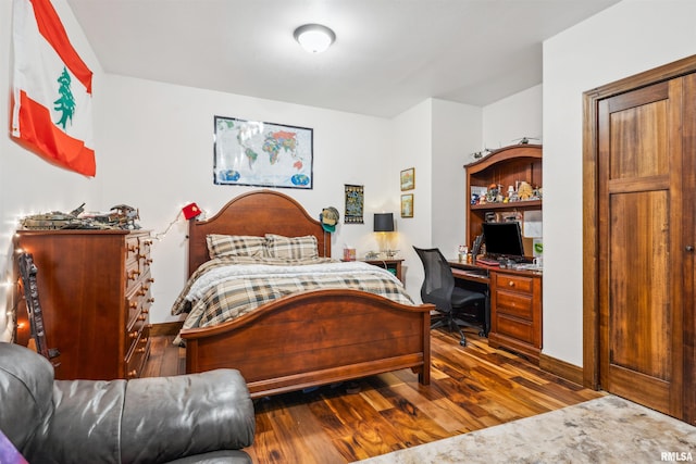 bedroom with dark hardwood / wood-style floors