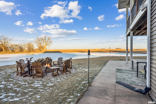 view of patio with a fire pit and a water view