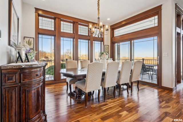 dining space with dark wood-type flooring and a notable chandelier