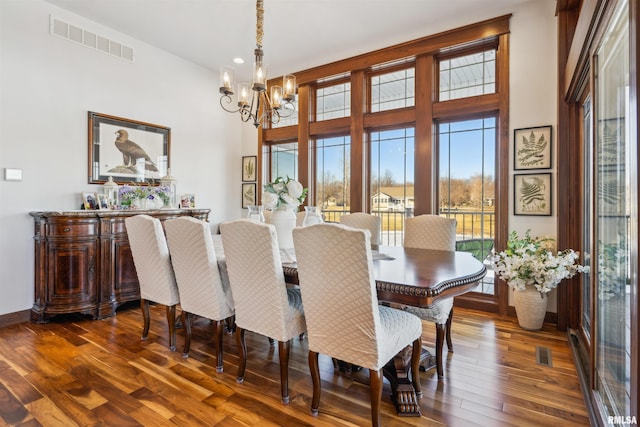 dining space with dark hardwood / wood-style flooring and a notable chandelier