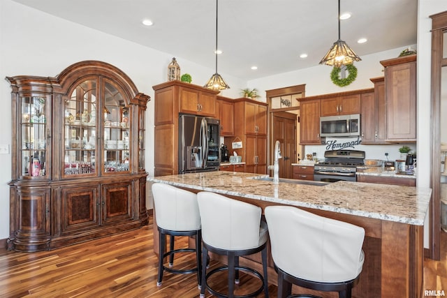 kitchen featuring appliances with stainless steel finishes, pendant lighting, a spacious island, and sink