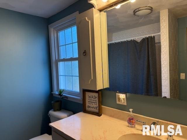 bathroom with toilet, vanity, and a shower with shower curtain