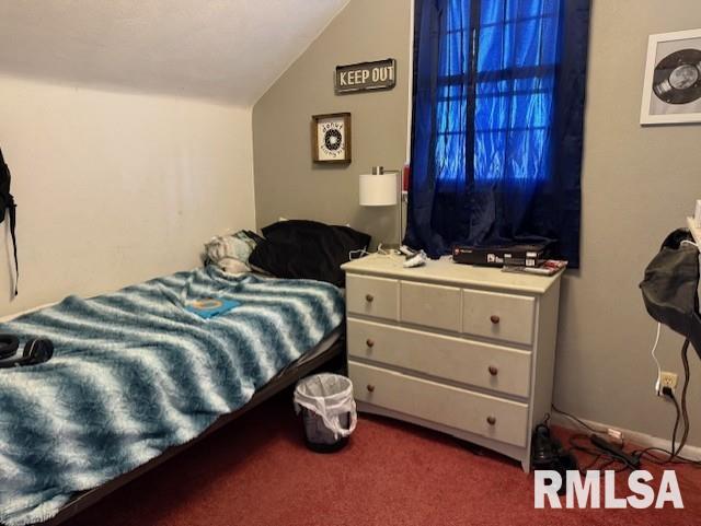 carpeted bedroom with lofted ceiling