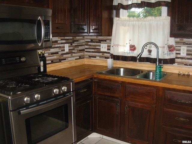 kitchen featuring butcher block counters, sink, tasteful backsplash, and appliances with stainless steel finishes