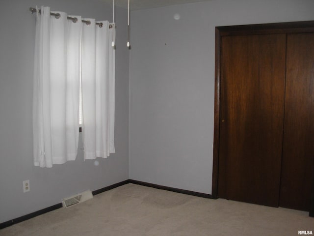 interior space featuring light carpet and a closet