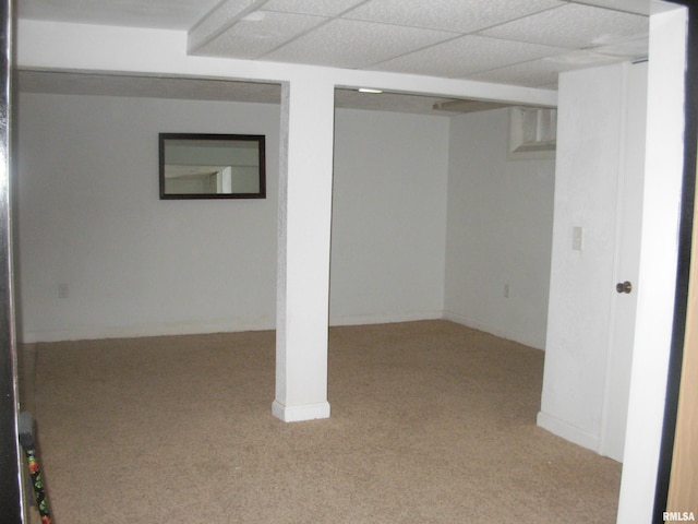 basement featuring light carpet and a paneled ceiling