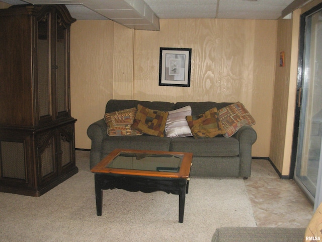 living room with wood walls and a drop ceiling