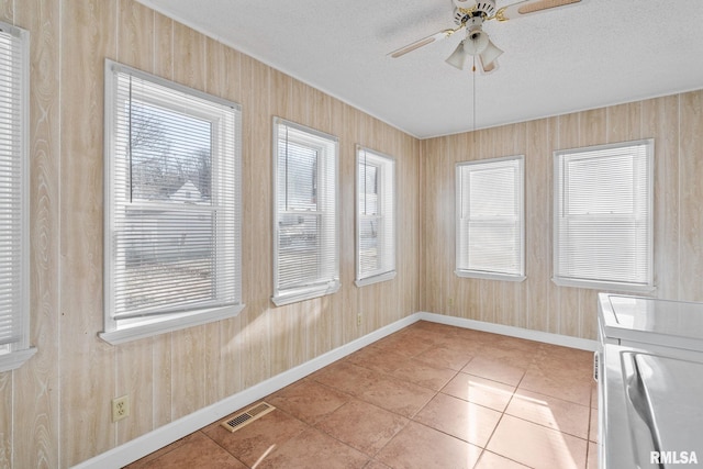 unfurnished sunroom featuring ceiling fan