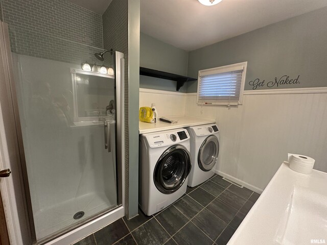 laundry room featuring dark tile patterned floors and washing machine and dryer