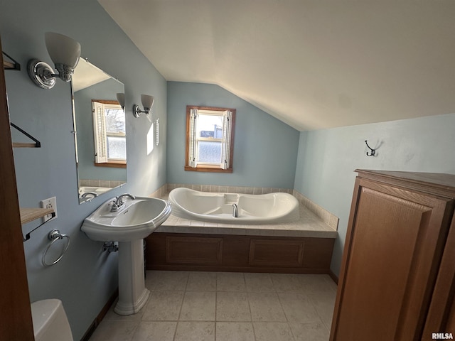 bathroom with lofted ceiling, a tub, tile patterned floors, and toilet