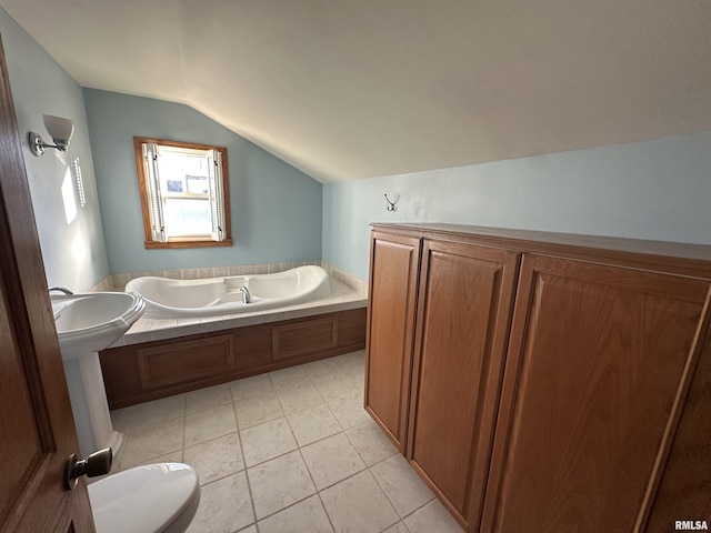 bathroom with toilet, lofted ceiling, tile patterned floors, a tub, and sink