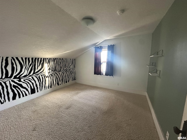 additional living space with lofted ceiling, carpet, and a textured ceiling