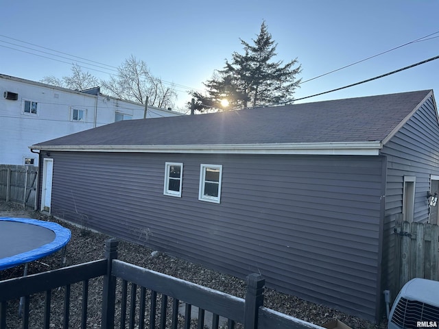 view of side of property with central AC unit and a trampoline