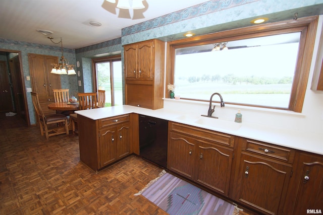 kitchen featuring pendant lighting, dark parquet flooring, black dishwasher, sink, and kitchen peninsula