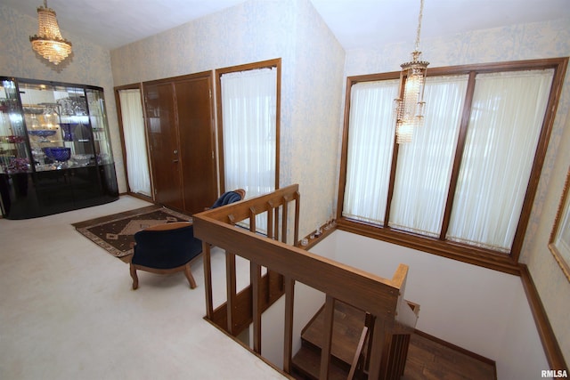 carpeted entrance foyer with a chandelier