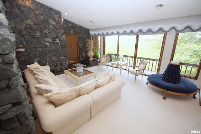 living room with lofted ceiling and a wood stove