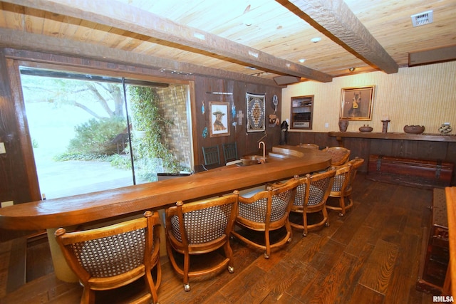 bar with wooden ceiling, dark hardwood / wood-style flooring, wooden walls, and beamed ceiling